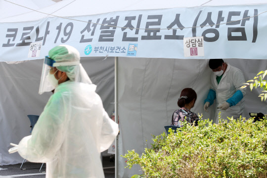 쿠팡 부천 물류센터 관련 신종 코로나바이러스 감염증(코로나19) 확진자가 속출하고 있는 가운데 27일 오후 경기도 부천시보건소 선별진료소에서 코로나19 검사를 받으러 온 시민이 상담을 받고 있다.  연합뉴스